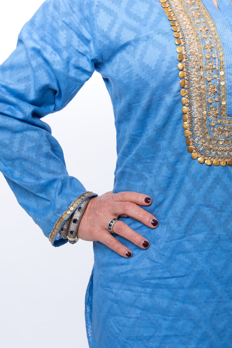 Hand woven blue tunic with intricate gold embroidery detail on sleeves, around the neck and on the back of the tunic. 