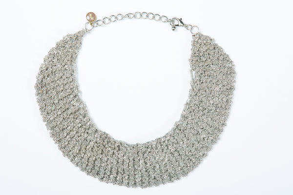 The Ella mesh necklace is hand crocheted and can be worn as a choler. It comes in 3 finishes, gold, white gold and black. 