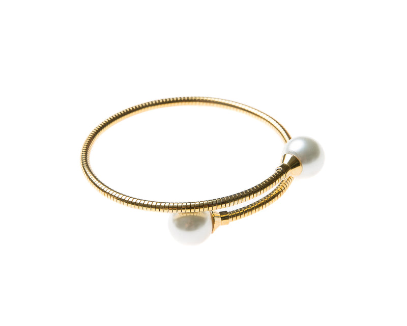 Delicate gold plated cuff bangle  adorned with pearl on either end. This cuff is easy to wear and fits most wrists. Can be worn alone or staked with other pieces. 