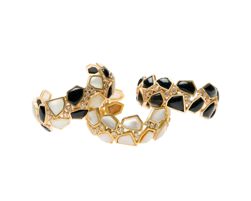 Asymmetrical natural black agate and mother of pearl are set in gold plated metal around Swarovski crystal to create this cuff that is easy to wear and fits most wrists. 