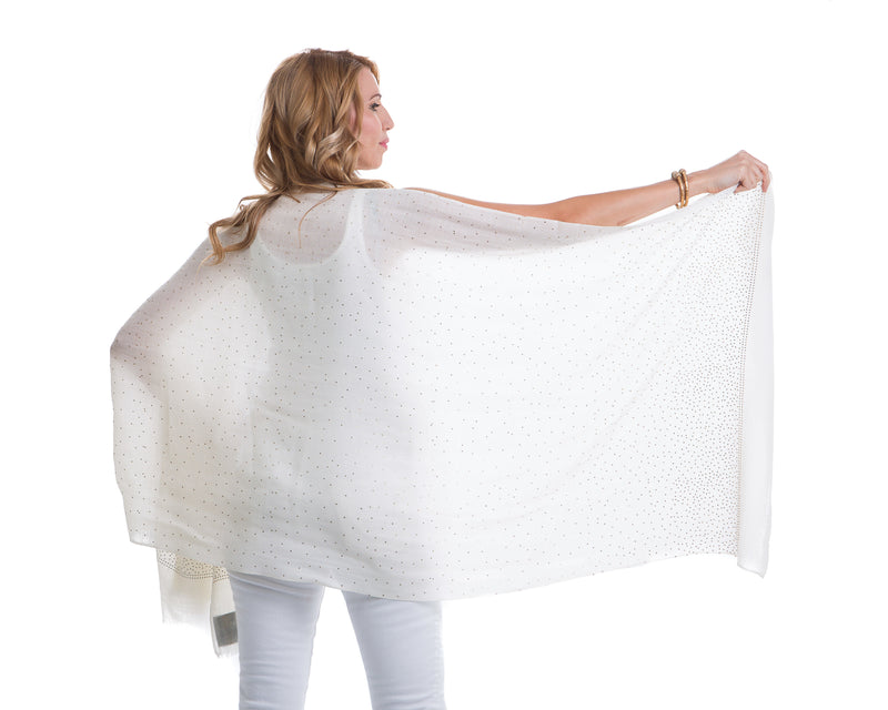 The Ethereal shawl is a hand woven light weight cashmere shawl that is embellished with gold Swarovski crystals over the entire length of the shawl. The shawl is sold in black or white. 