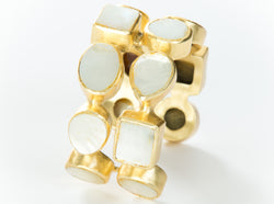 Two rows of natural white mother-of-pearl set in brass and 18k electro-gold plated. Adjusts to fit most wrists.