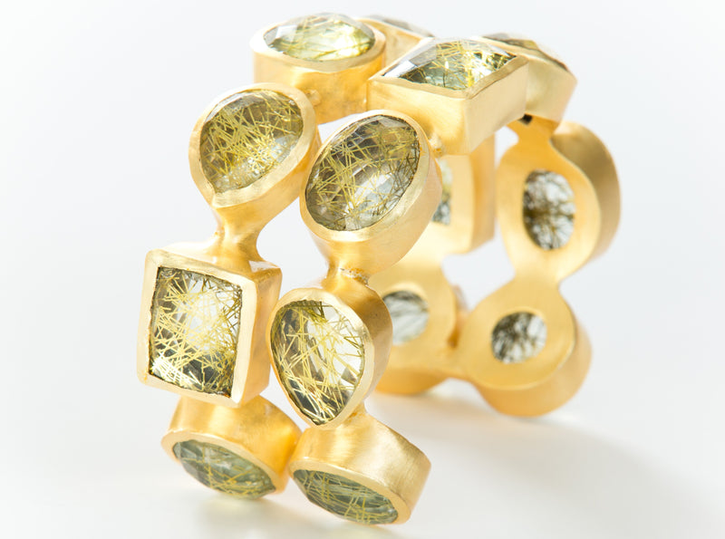 Two rows of natural gold rutilated quartz set in brass and 18k electro-gold plated. Adjusts to fit most wrists.