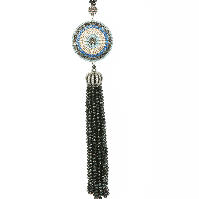 Classic evil eye dome tassel necklace with crystal and stone details. This necklace is worn long and is offered in shades of blue and black.