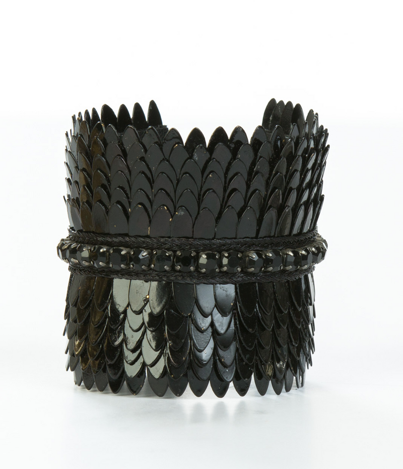 Wide gold plated cuff with feather cuts outs and a row of crystals in the center. The cuff is lined with soft leather for comfort. It is a significant piece that could be worn casually or to a black tie event.  It is offered in 3 finishes.