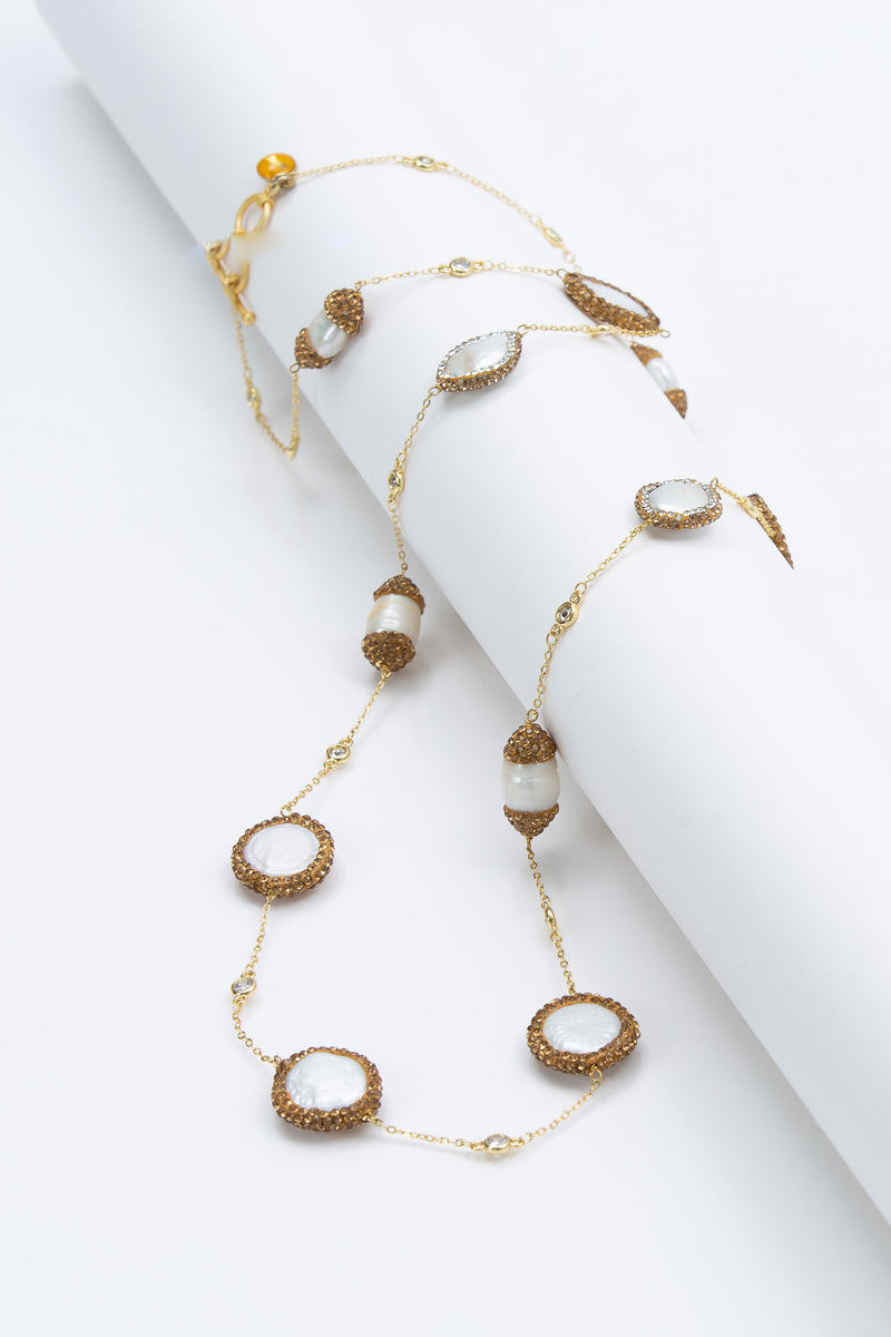The Elsa flat pearls necklace is 39 “ long. Each freshwater pearl is encrusted with Swarovski  crystals. A toggle clasp allows for the necklace to be worn long or doubled. 