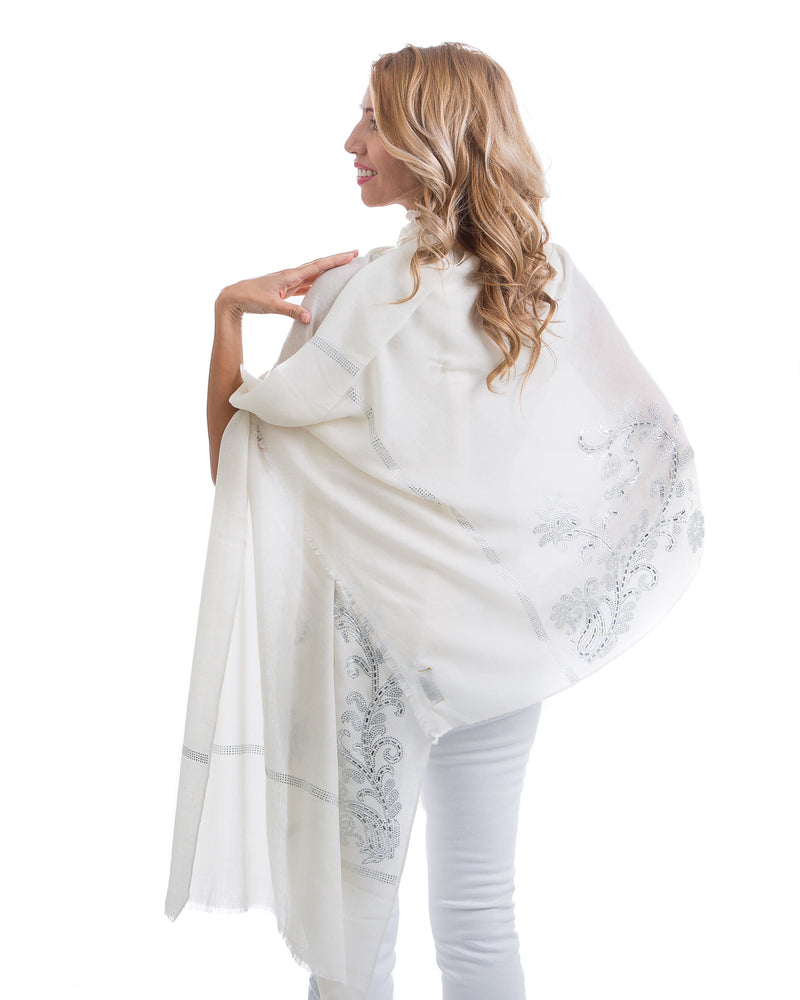 The image showcases the Yatra Halcyon Shawl that is offered in black and white. The cashmere shawl is decorated with large floral motifs at the two ends of the shawl with Swaravoski crystals in varied shapes and sizes. 