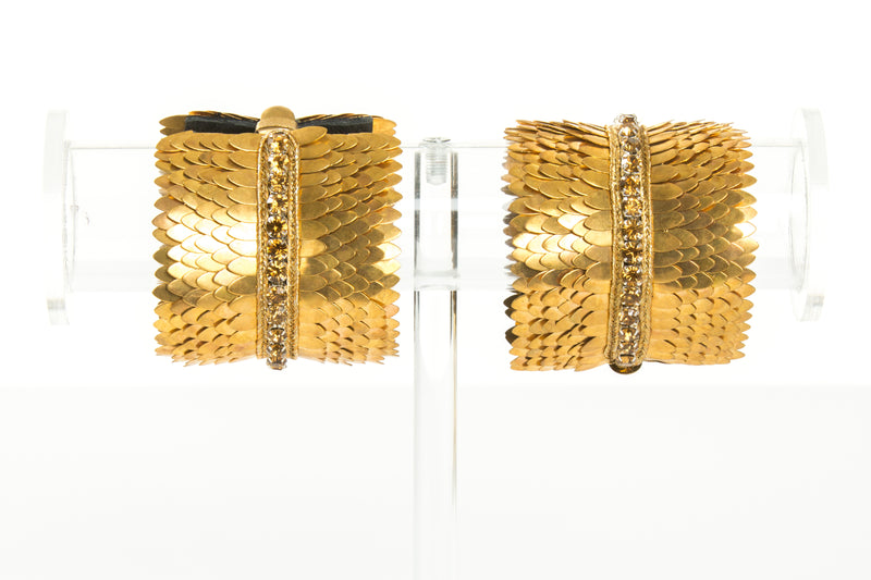 Wide gold plated cuff with feather cuts outs and a row of crystals in the center. The cuff is lined with soft leather for comfort. It is a significant piece that could be worn casually or to a black tie event.  It is offered in 3 finishes.