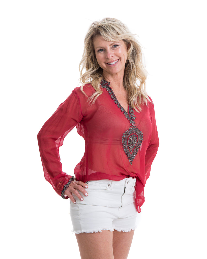 The Ibiza tunic is a sheer chiffon tunic with grey beading and embroidery around the neck and edge of the sleeves. This top is offered in red and black.