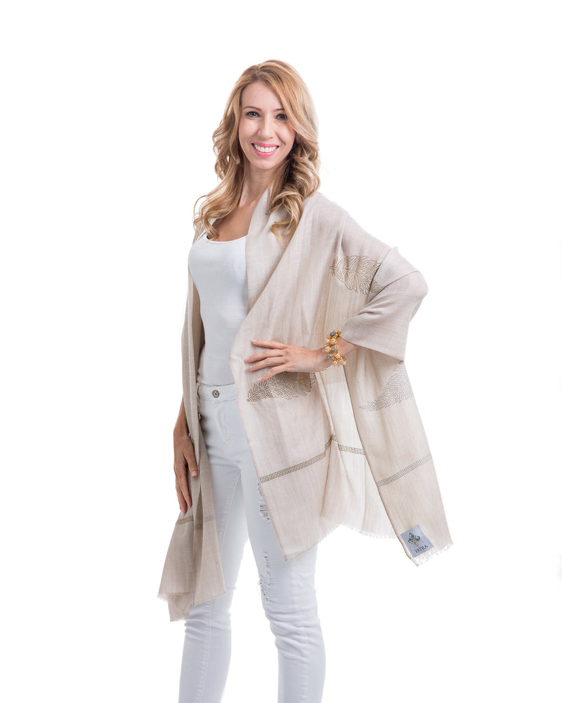 The Elixir cashmere shawl is embellished with Swarovski crystals. The crystals form a  leaf pattern all over the shawl. Two rows of crystals form a border along the two ends of the width. 