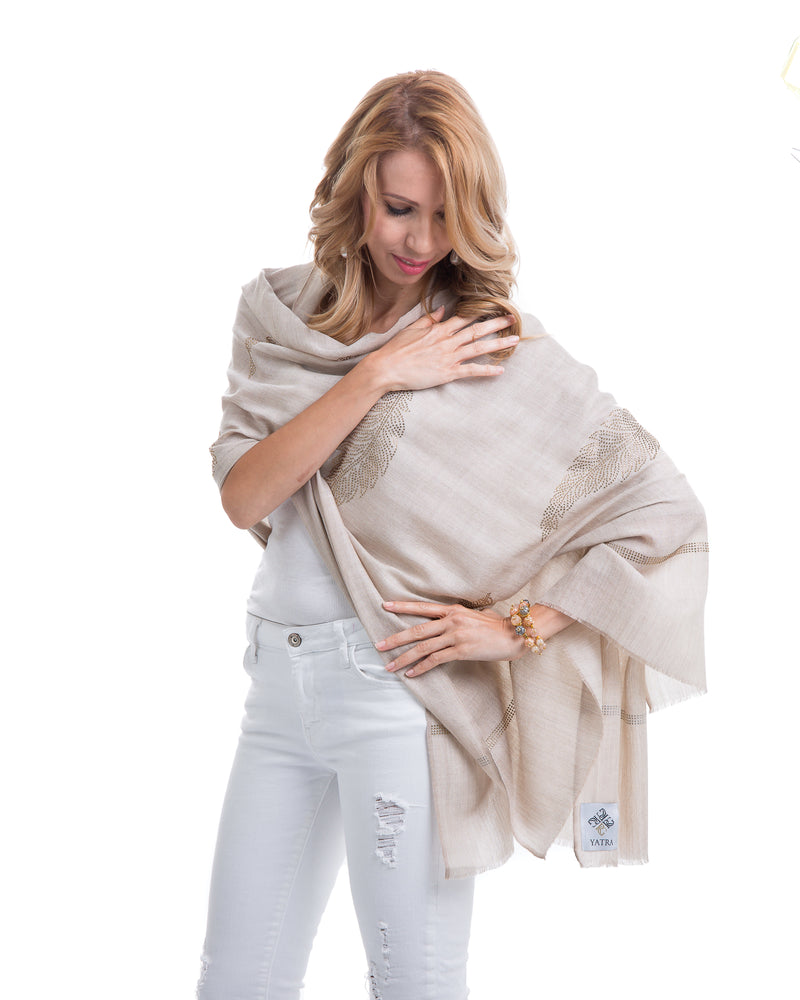 The Elixir cashmere shawl is embellished with Swarovski crystals. The crystals form a  leaf pattern all over the shawl. Two rows of crystals form a border along the two ends of the width. 