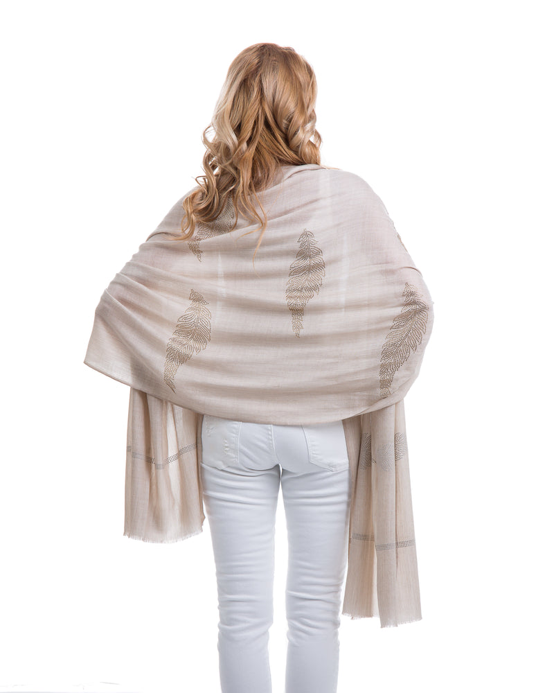 The Elixir cashmere shawl is embellished with Swarovski crystals. The crystals form a  leaf pattern all over the shawl. Two rows of crystals form a border along the two ends of the width. 