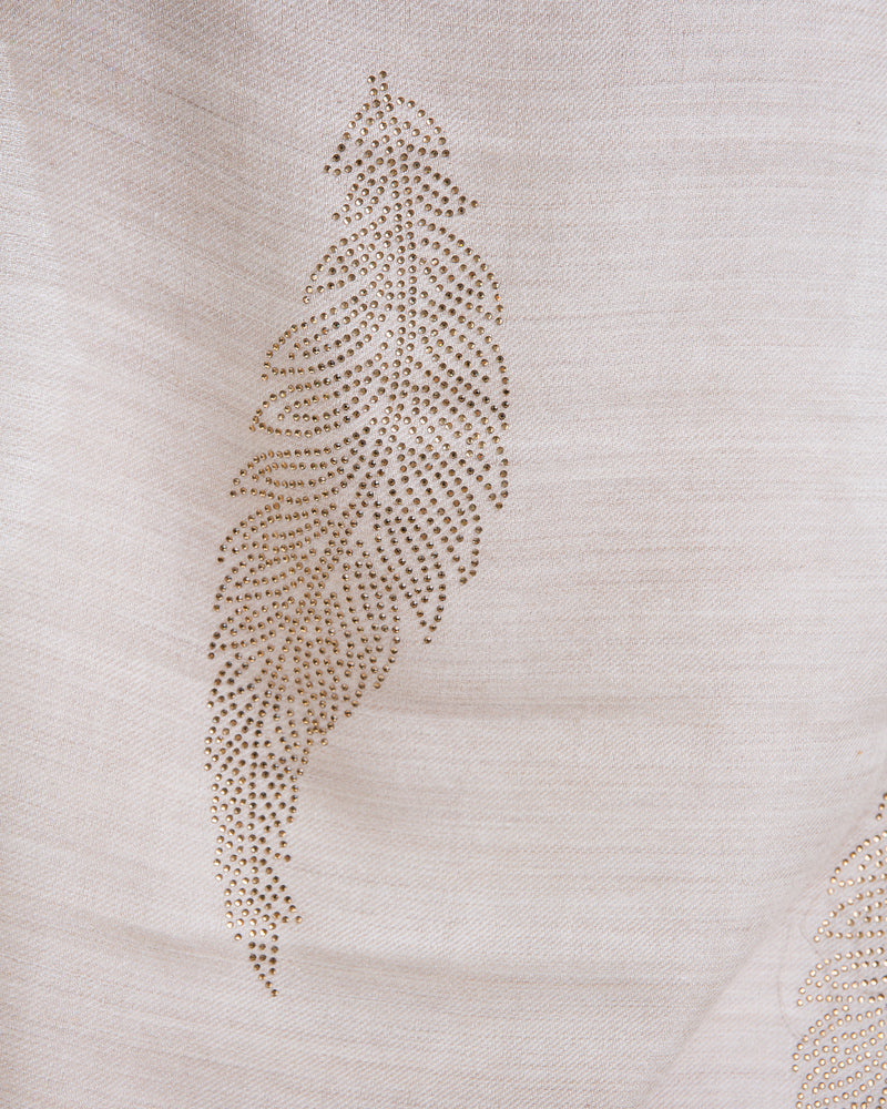 The Elixir cashmere shawl is embellished with Swarovski crystals. The crystals form a  leaf pattern all over the shawl. Two rows of crystals form a border along the two ends of the width. 