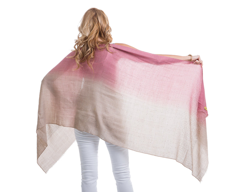 This image showcases our Felicity shawl. This is a cashmere shawl with an ombre effect ranging from pink to wheat. The shawl is decorated with gold and silver swarovski crystals on the entire shawl. The shawl is 81” X 29”.