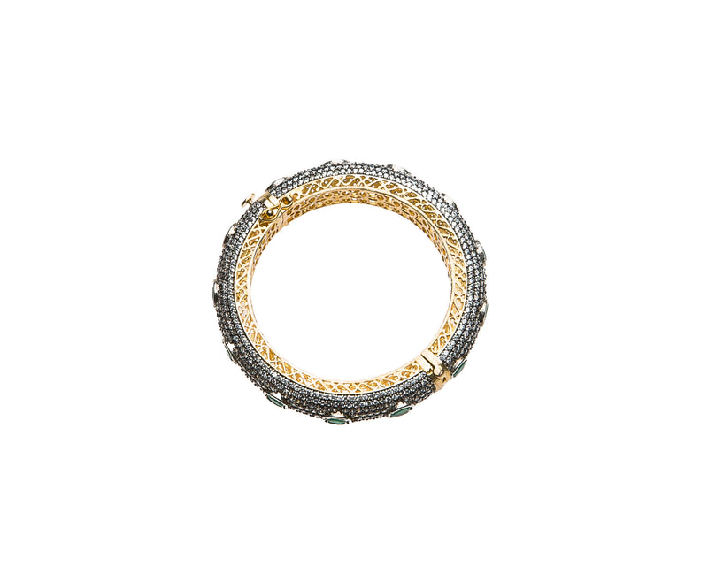 Hand-crafted bracelet with hinge in the center is easy to wear. The cuff is covered in clear Swarovski crystals. Semi precious green oval stones are spaced in intervals along the cuff.There is delicate filigree detail on the inside of the bracelet. The bracelet is 18k gold plated. 