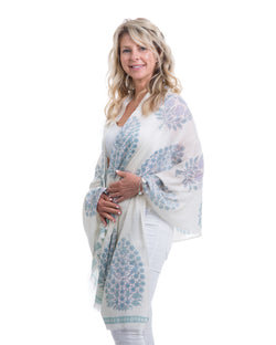 The Islamorada Shawl is a block printed shawl. The base of the shawl is white with bold floral block pints in shades of blue.