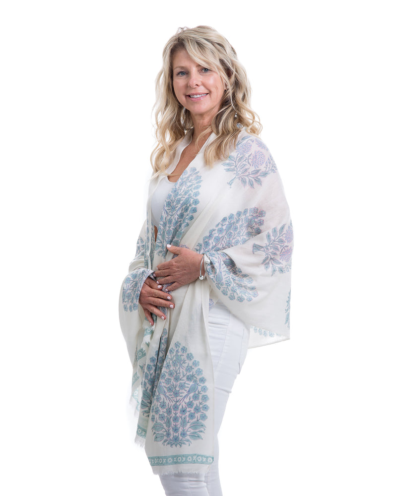 The Islamorada Shawl is a block printed shawl. The base of the shawl is white with bold floral block pints in shades of blue.