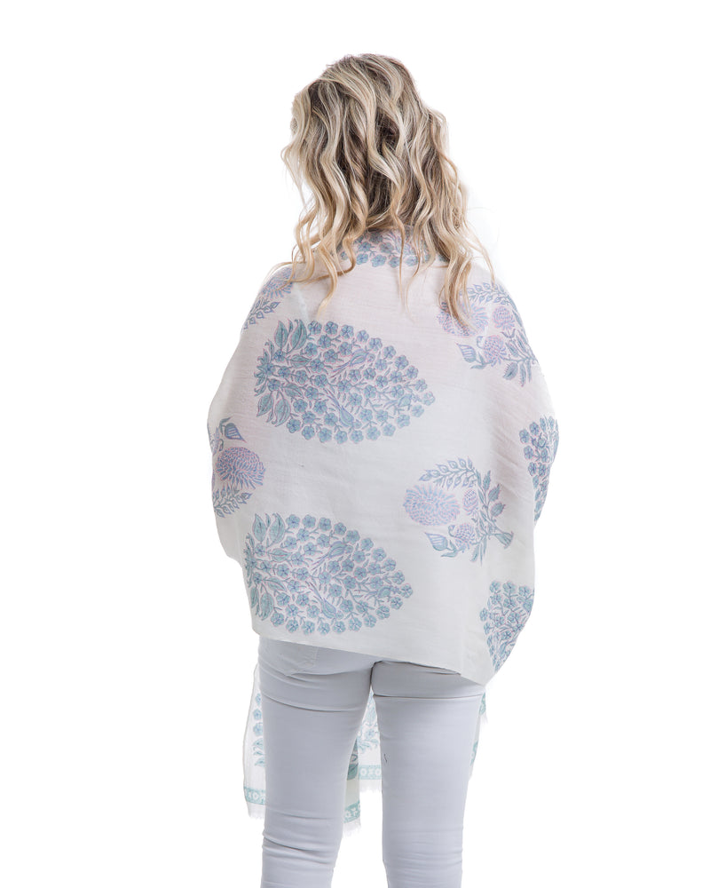 The Islamorada Shawl is a block printed shawl. The base of the shawl is white with bold floral block pints in shades of blue.