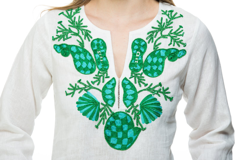 White linen tunic with substantial hand embroidery with faux coral detail. The embroidery is in either green, red or blue. Embroidery detail in around the neck, sleeves and at the bottom of the tunic. 