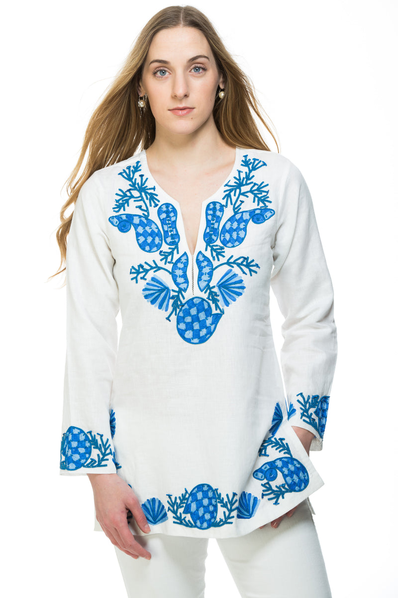 White linen tunic with substantial hand embroidery with faux coral detail. The embroidery is in either green, red or blue. Embroidery detail in around the neck, sleeves and at the bottom of the tunic. 