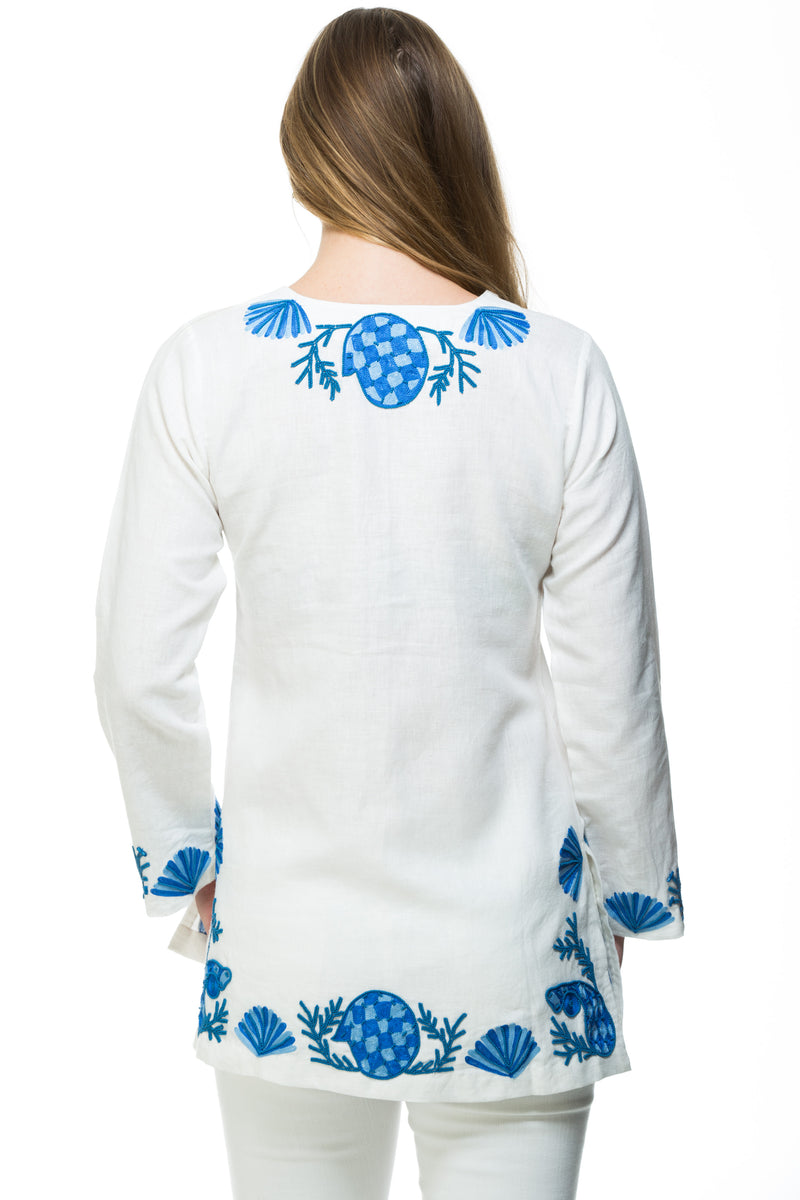 White linen tunic with substantial hand embroidery with faux coral detail. The embroidery is in either green, red or blue. Embroidery detail in around the neck, sleeves and at the bottom of the tunic. 