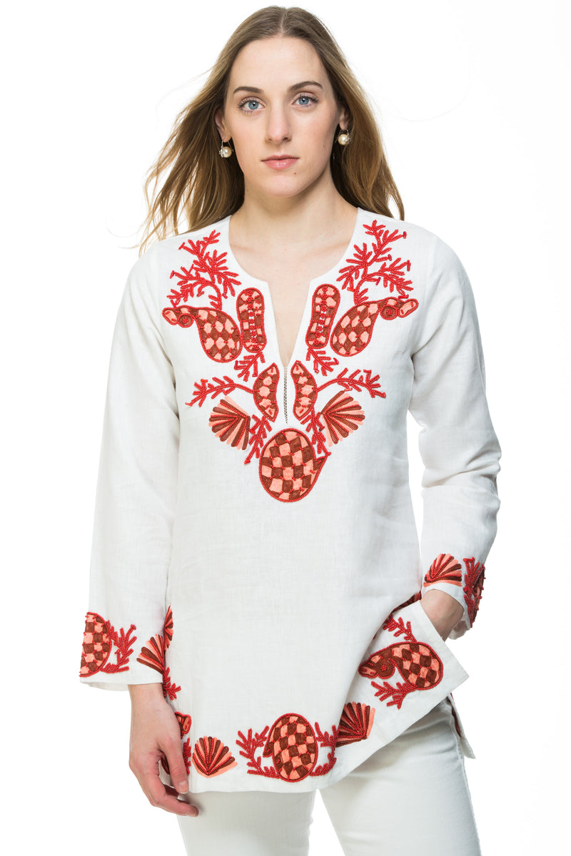 White linen tunic with substantial hand embroidery with faux coral detail. The embroidery is in either green, red or blue. Embroidery detail in around the neck, sleeves and at the bottom of the tunic. 