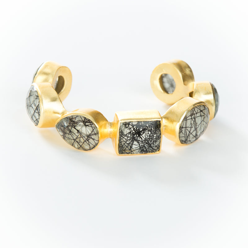 Natural black rutilated quartz stones set in brass and 18k electro-gold plated. Adjusts to fit most wrists.