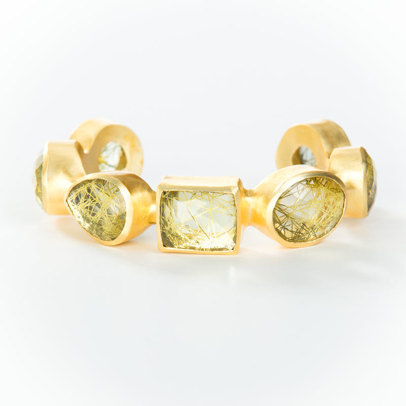 Natural yellow rutilated quartz set in brass and 18k electro-gold plated. Adjusts to fit most wrists.