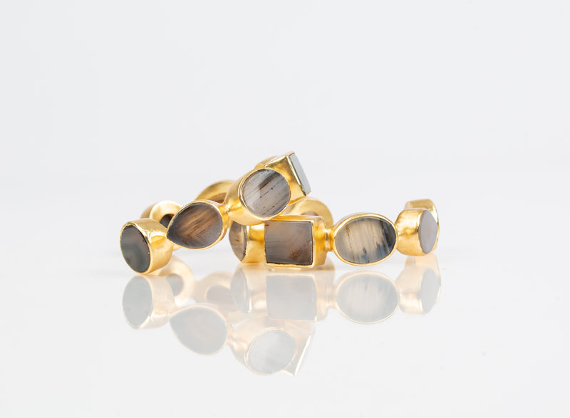 Natural slate mother-of-pearl stones set in brass and 18k electro-gold plated. Adjusts to fit most wrists.