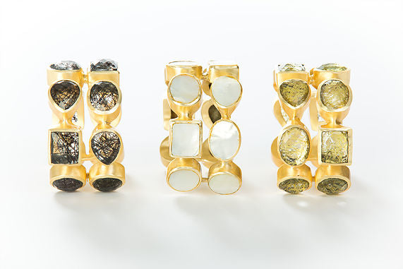 Two rows of natural white mother-of-pearl set in brass and 18k electro-gold plated. Adjusts to fit most wrists.